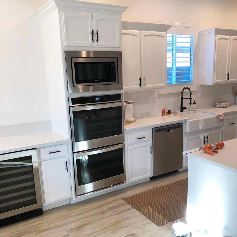 White cabinet kitchen with stainless appliances.