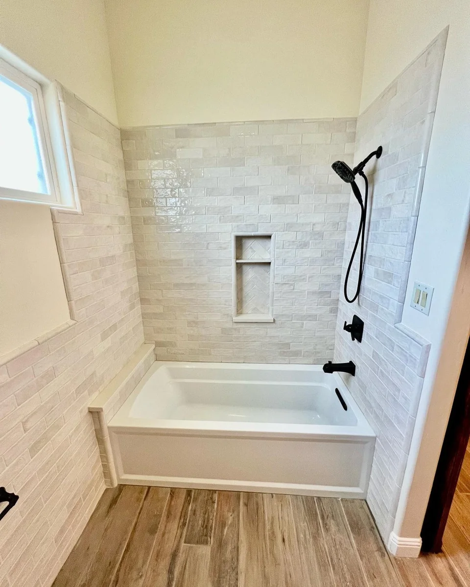 Neutral tile bathroom tub and shower.