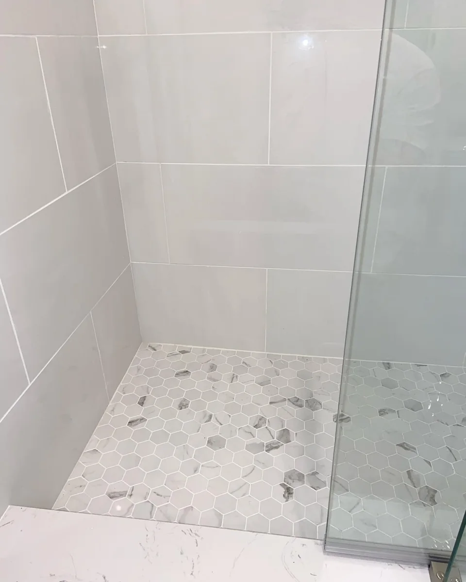 Walk-in shower glass and tile detail.