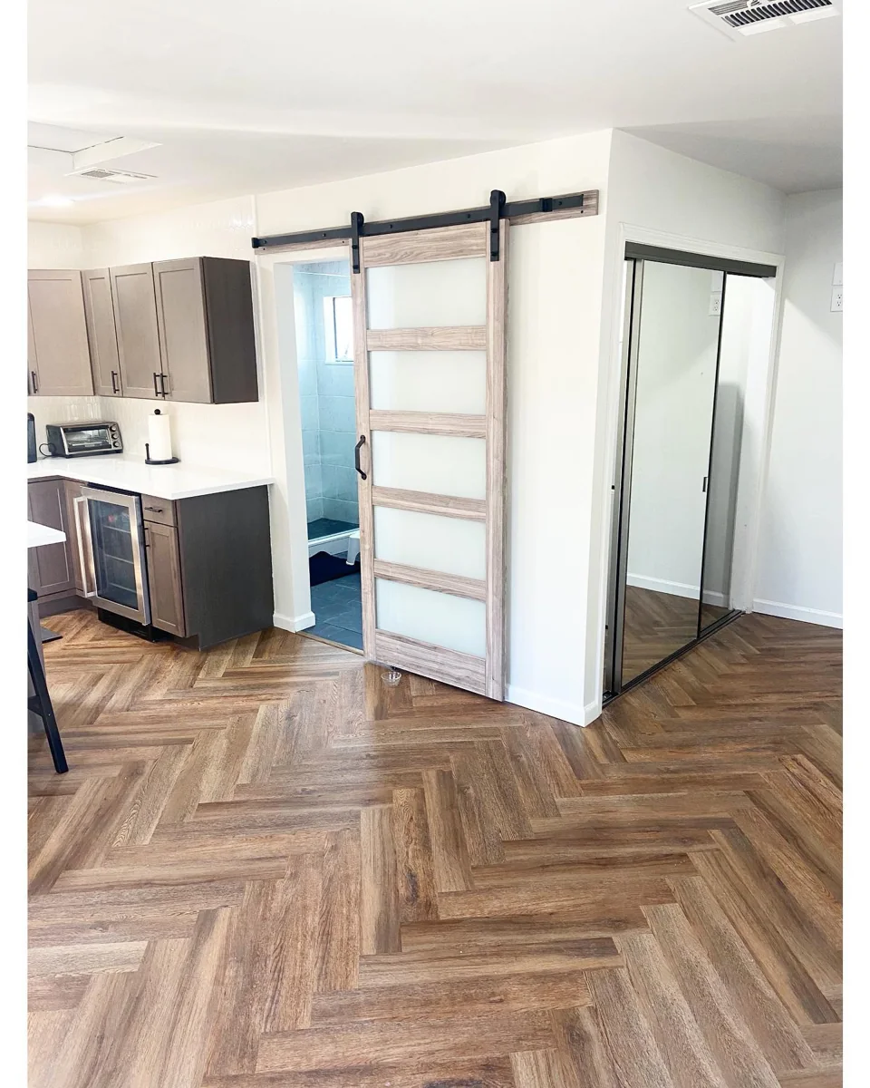 Herringbone wood-look flooring and barn doors.