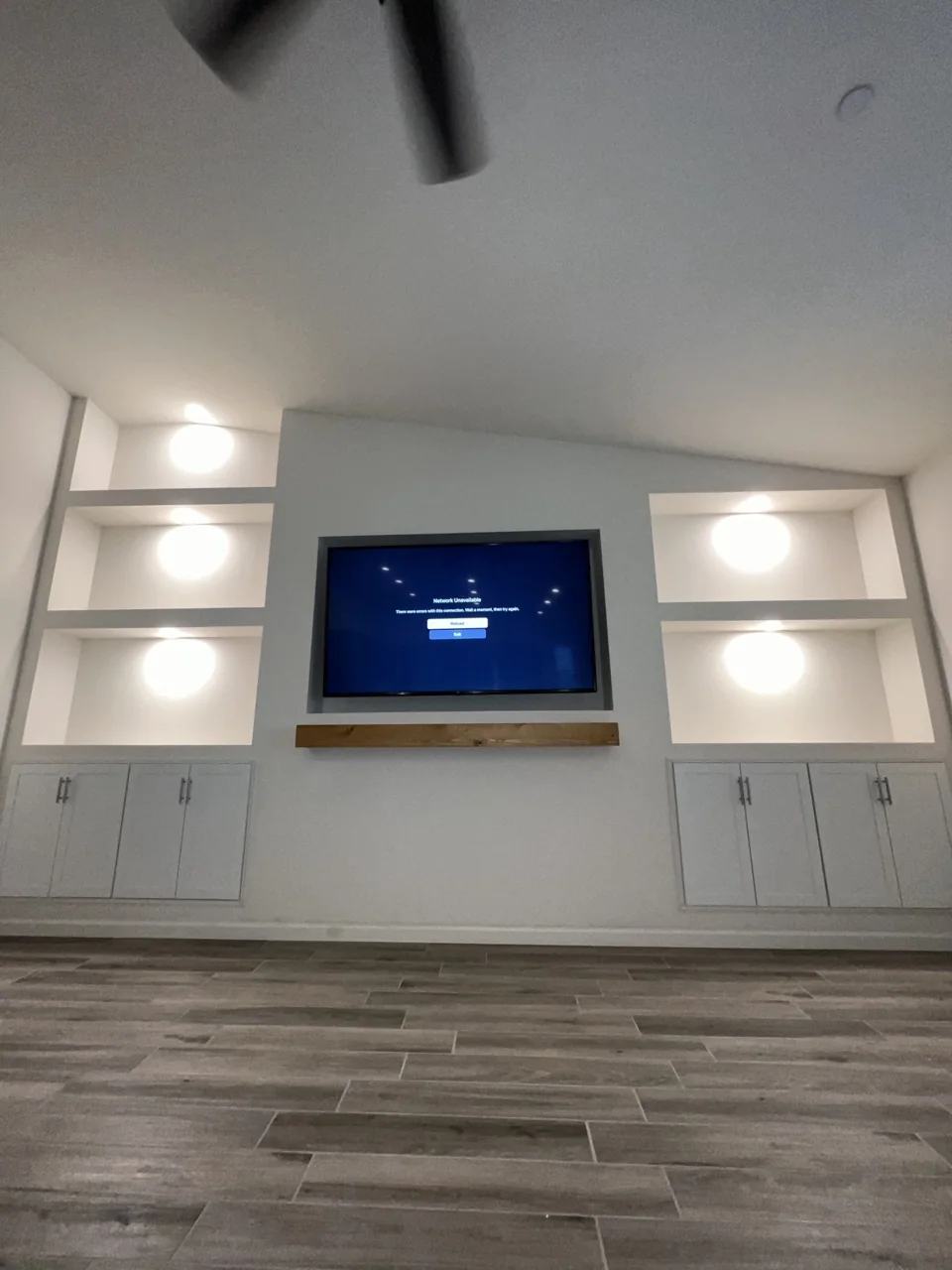 A fitted media wall with display lighting and coordinated storage.