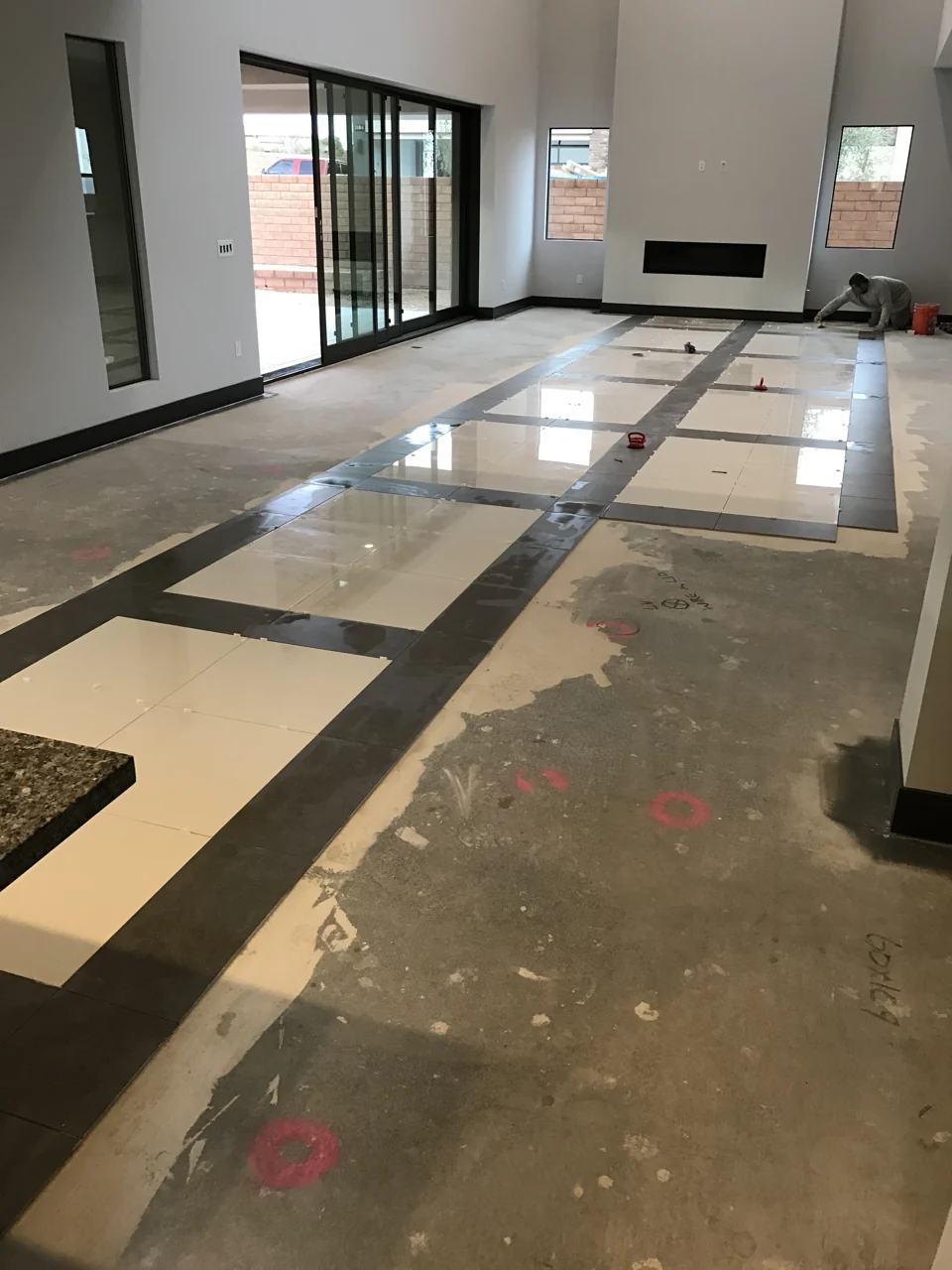 Work in progress: contrasting tile bands take shape across the room before the surrounding floor is installed.