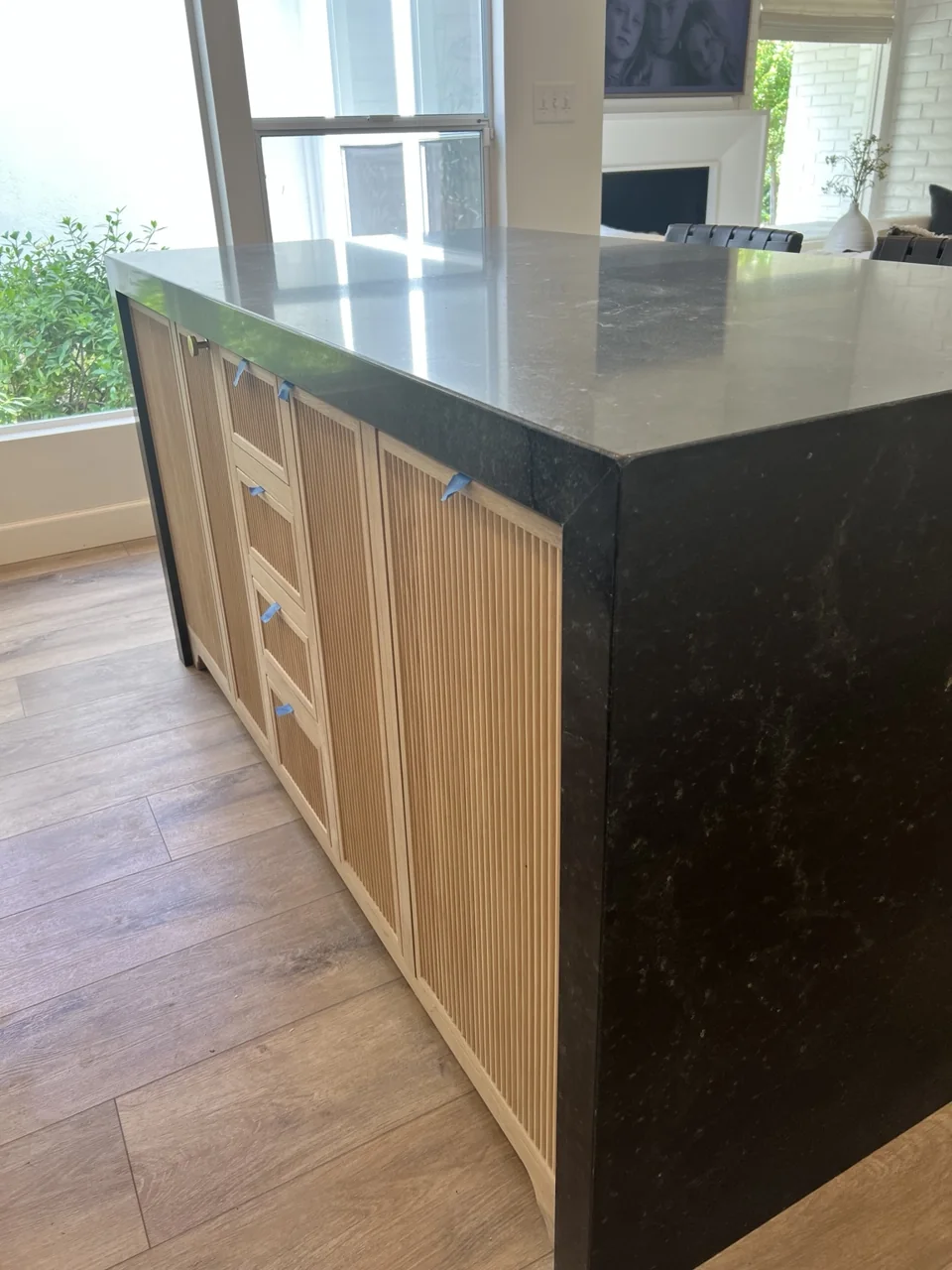 A closer look at the waterfall countertop and wood cabinetry.