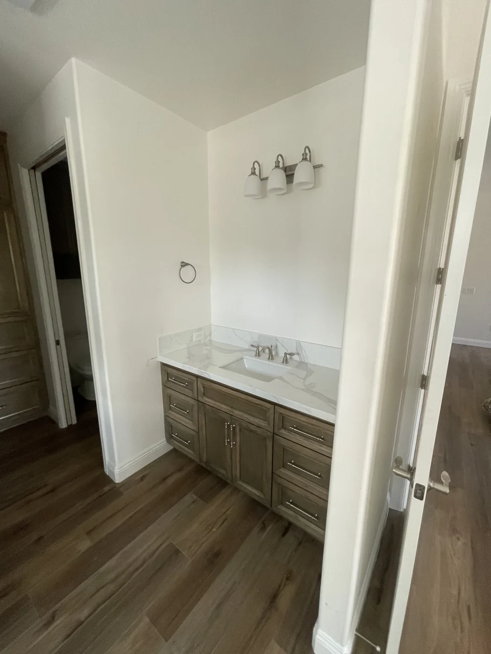 Work in progress: wood vanity cabinetry and a pale countertop, photographed before the mirror was installed.